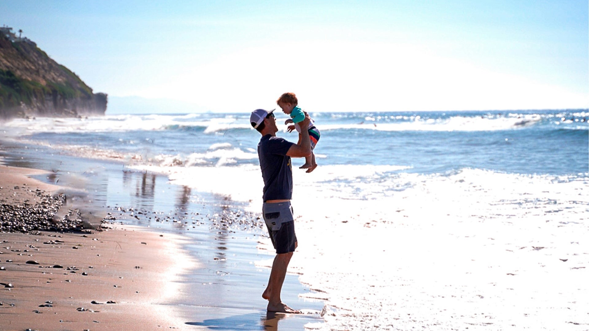 father and a baby boy at the beach